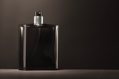 Luxury men`s perfume in bottle on grey table, space for text