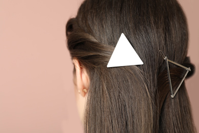 Photo of Young woman with beautiful hair clips on pink background, closeup
