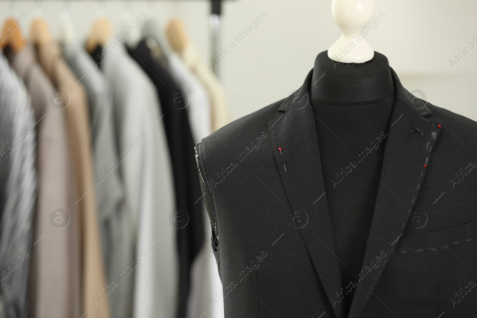 Photo of Mannequin with unfinished jacket in tailor shop, closeup. Space for text