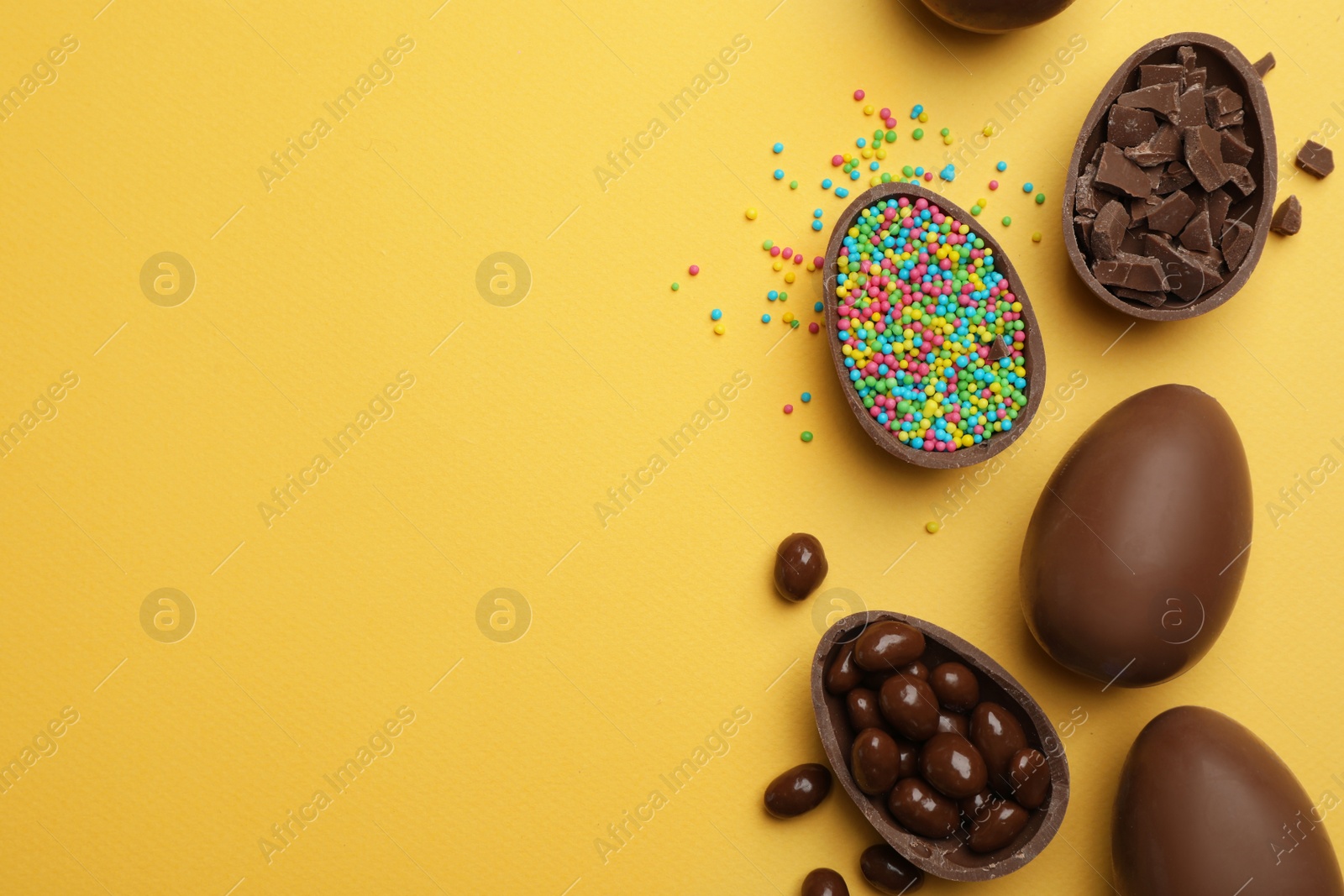 Photo of Tasty chocolate Easter eggs on color background, flat lay with space for text