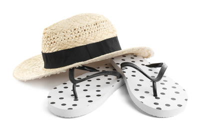 Stylish flip flops and hat on white background