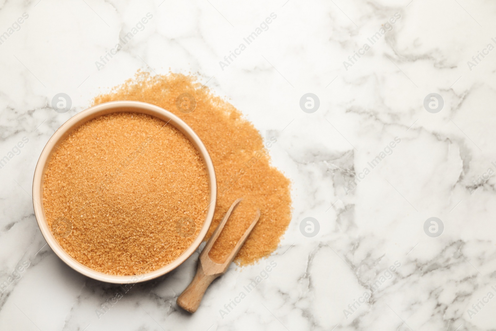 Photo of Brown sugar on white marble table, flat lay. Space for text