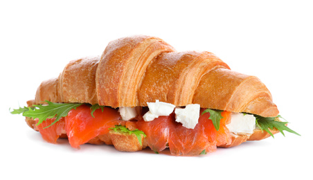 Tasty croissant sandwich with red fish isolated on white