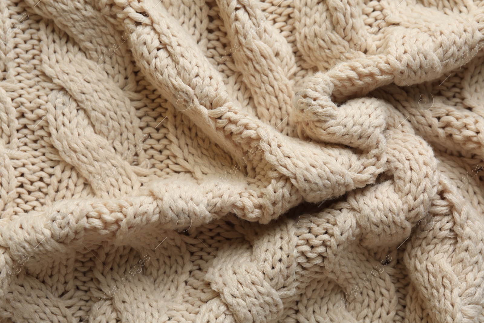 Photo of Beige knitted fabric with beautiful pattern as background, top view