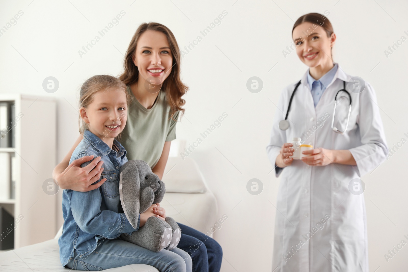 Photo of Mother and daughter visiting pediatrician. Doctor working with patient in hospital