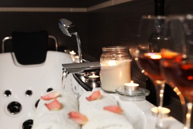 Photo of Candles and towels on tub in bathroom, space for text. Romantic atmosphere