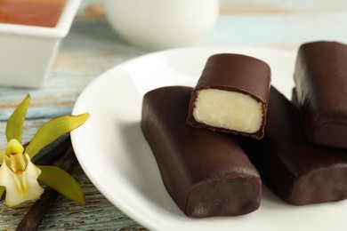 Photo of Glazed vanilla curd cheese bars served on wooden table, closeup