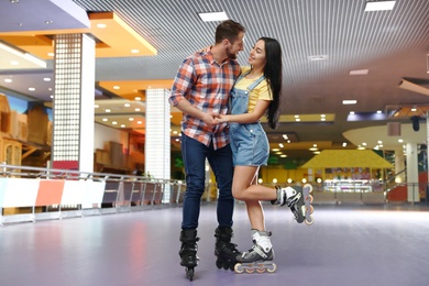 Young couple spending time at roller skating rink