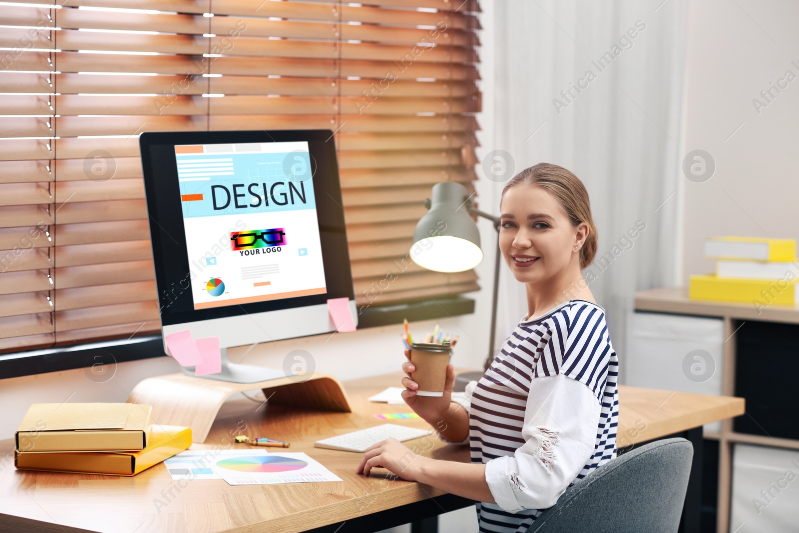 Image of Professional female designer working at desk in modern office