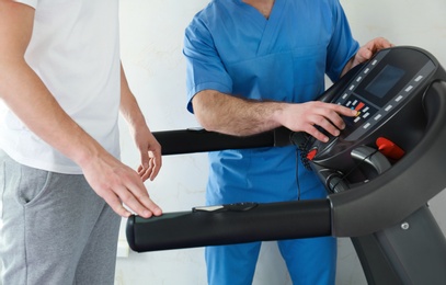 Photo of Patient exercising under physiotherapist supervision in rehabilitation center, closeup