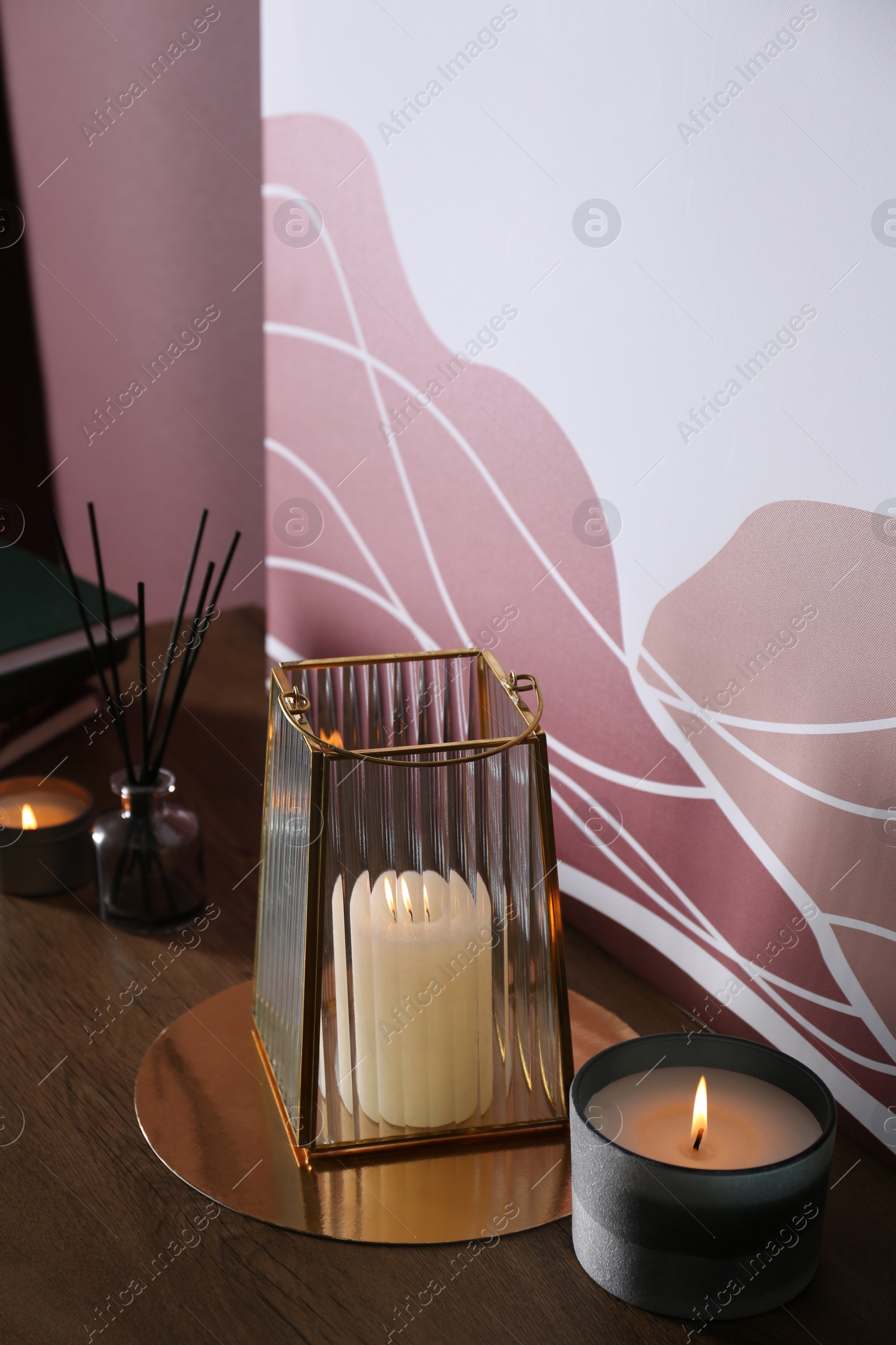 Photo of Burning scented candles on wooden table indoors