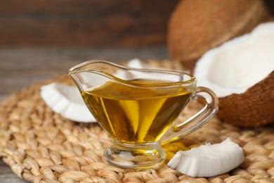 Photo of Gravy boat with coconut oil on wicker mat. Healthy cooking