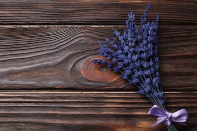 Bouquet of beautiful preserved lavender flowers on wooden table, top view. Space for text