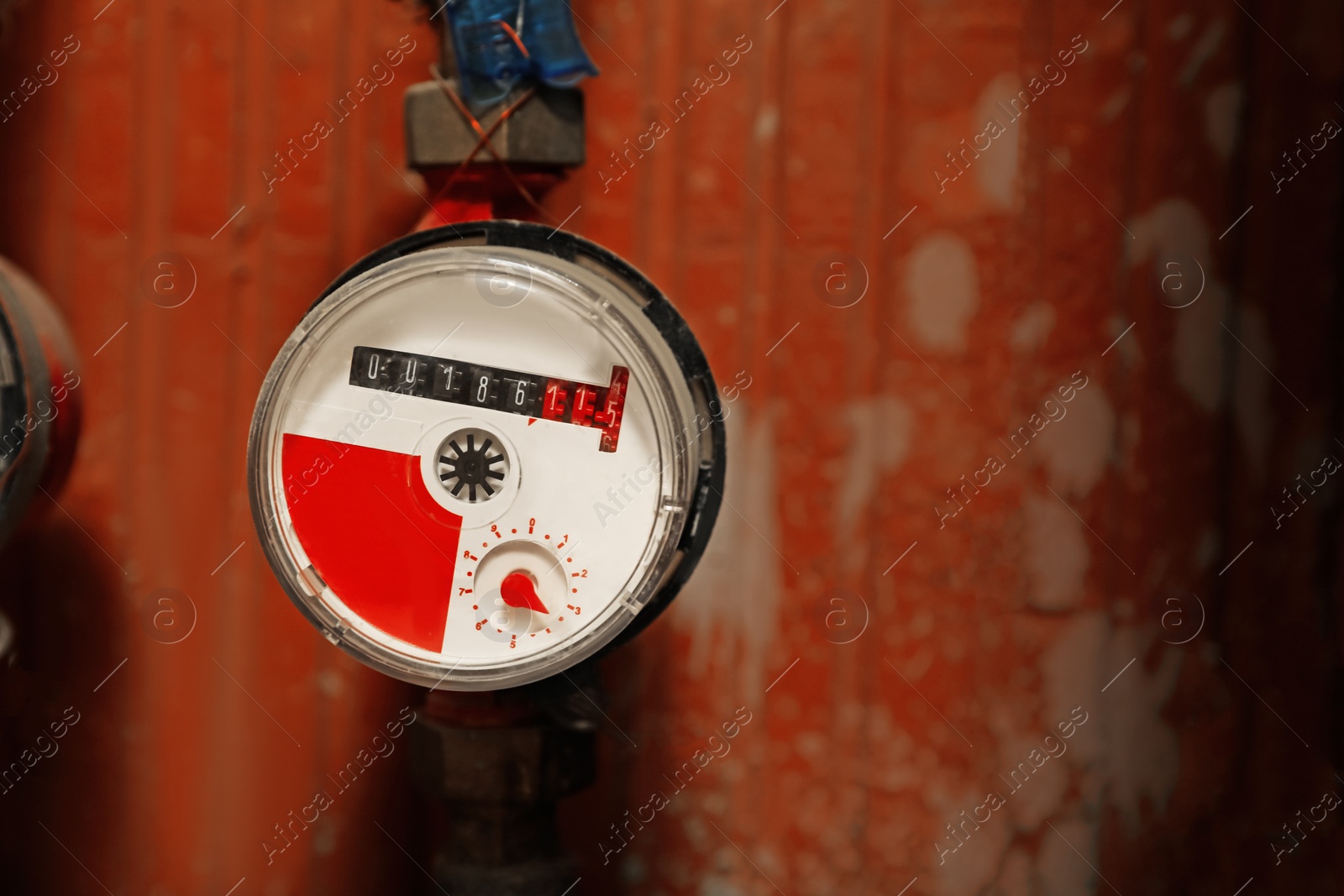 Photo of Electric meter near red brick wall, space for text. Water measuring device
