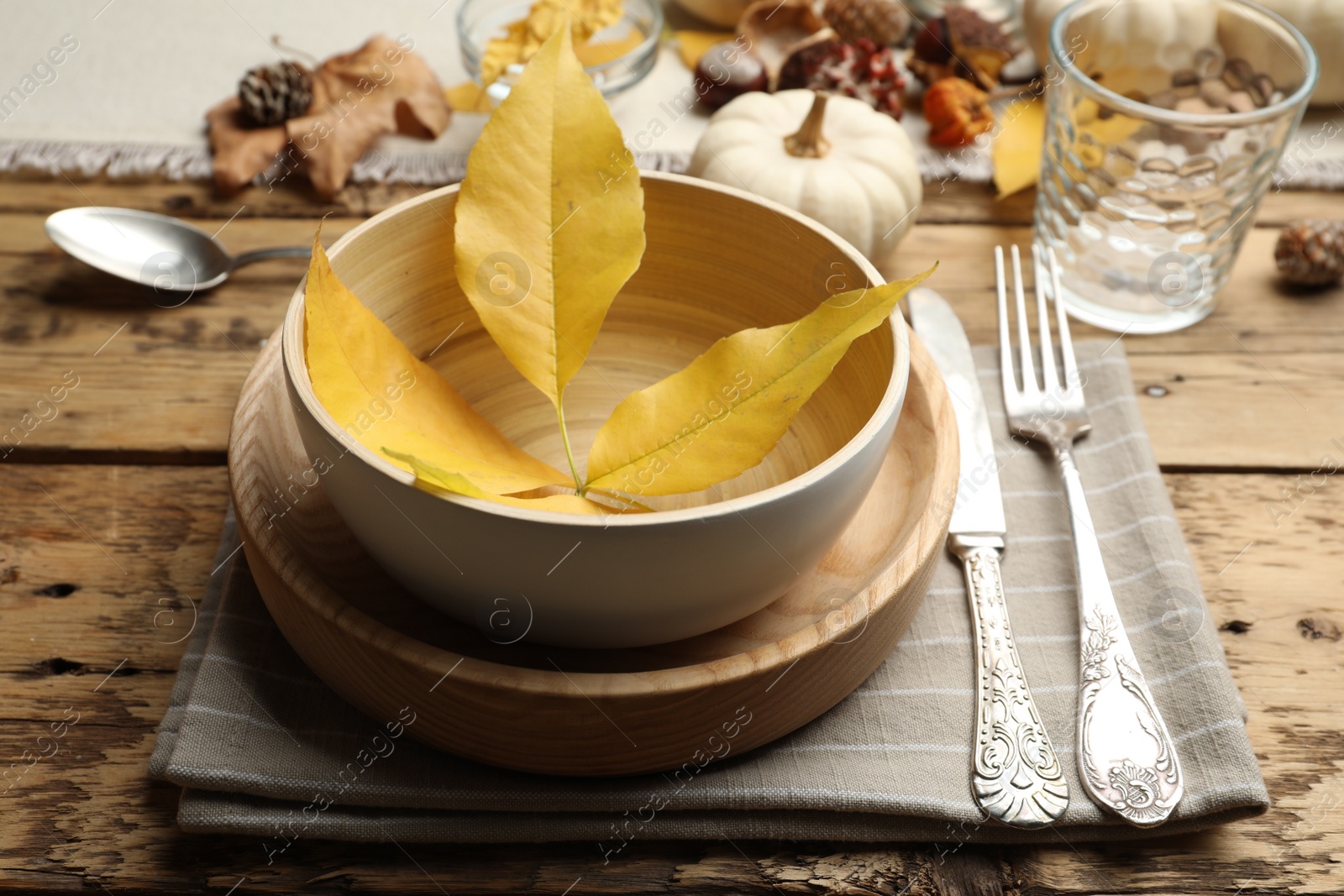 Photo of Autumn table setting with fallen leaves on wooden background