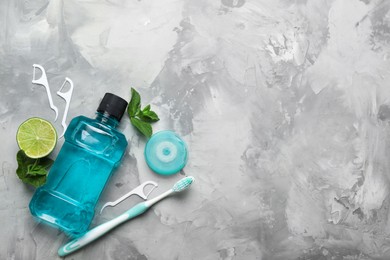 Photo of Flat lay composition with mouthwash and other oral hygiene products on grey marble background. Space for text