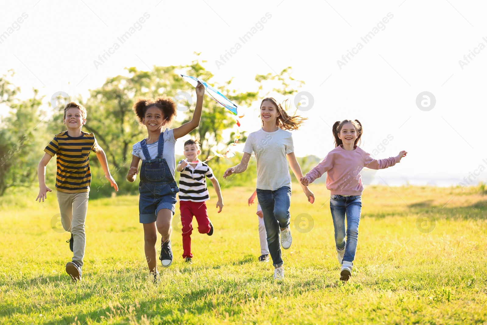 Photo of Cute little children playing with kite outdoors on sunny day