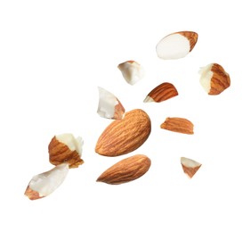 Image of Pieces of tasty almonds falling on white background