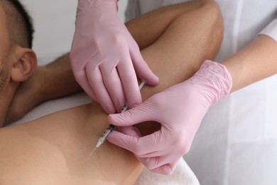 Photo of Cosmetologist injecting man's armpit, closeup. Treatment of hyperhidrosis