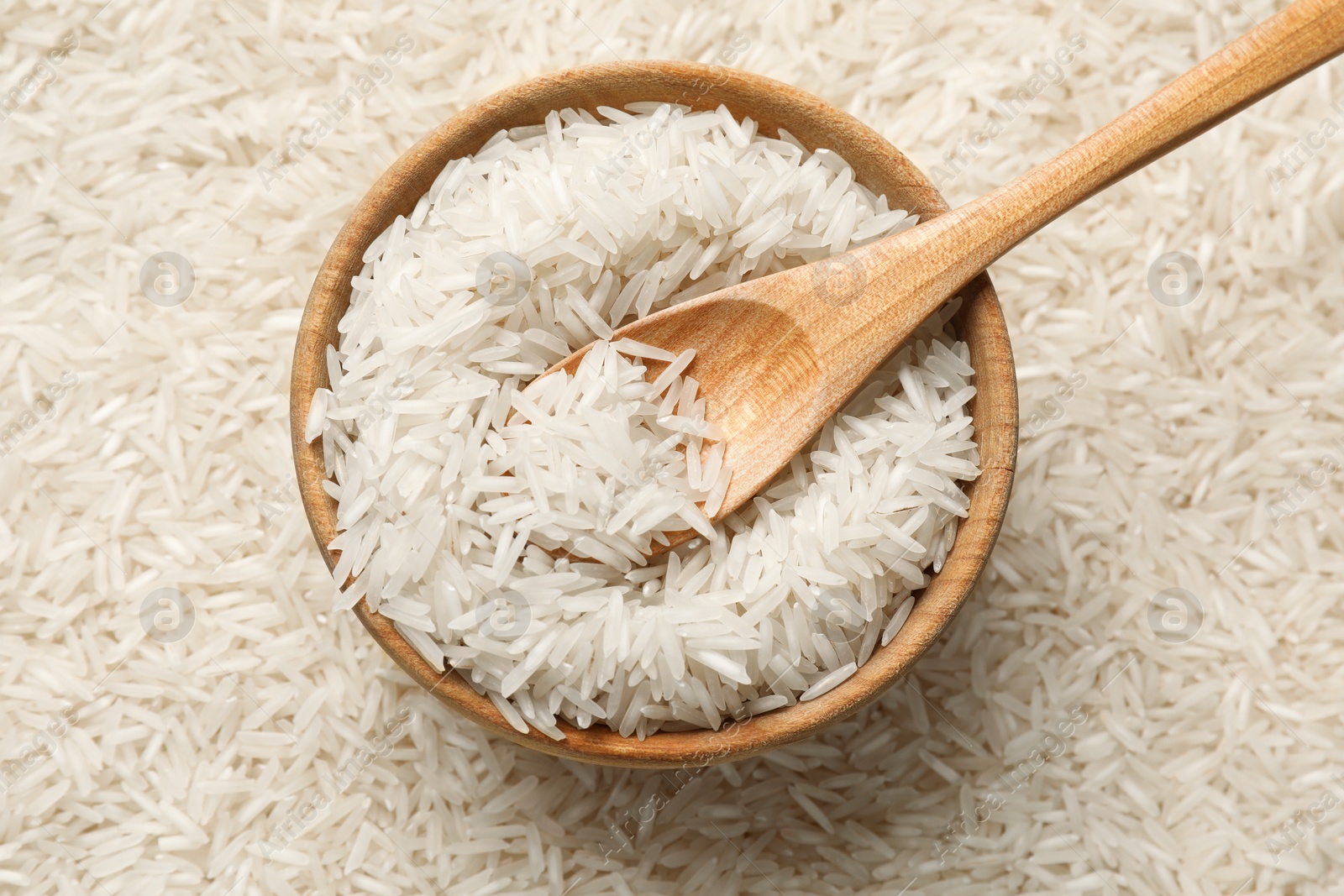 Photo of Raw basmati rice, bowl and spoon, top view