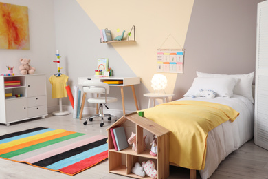 Stylish child room interior with comfortable bed and desk