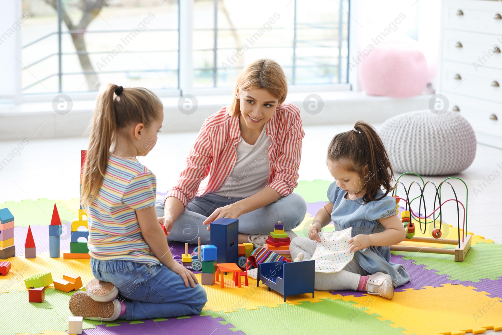 Photo of Mother playing with her children at home