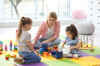 Photo of Mother playing with her children at home