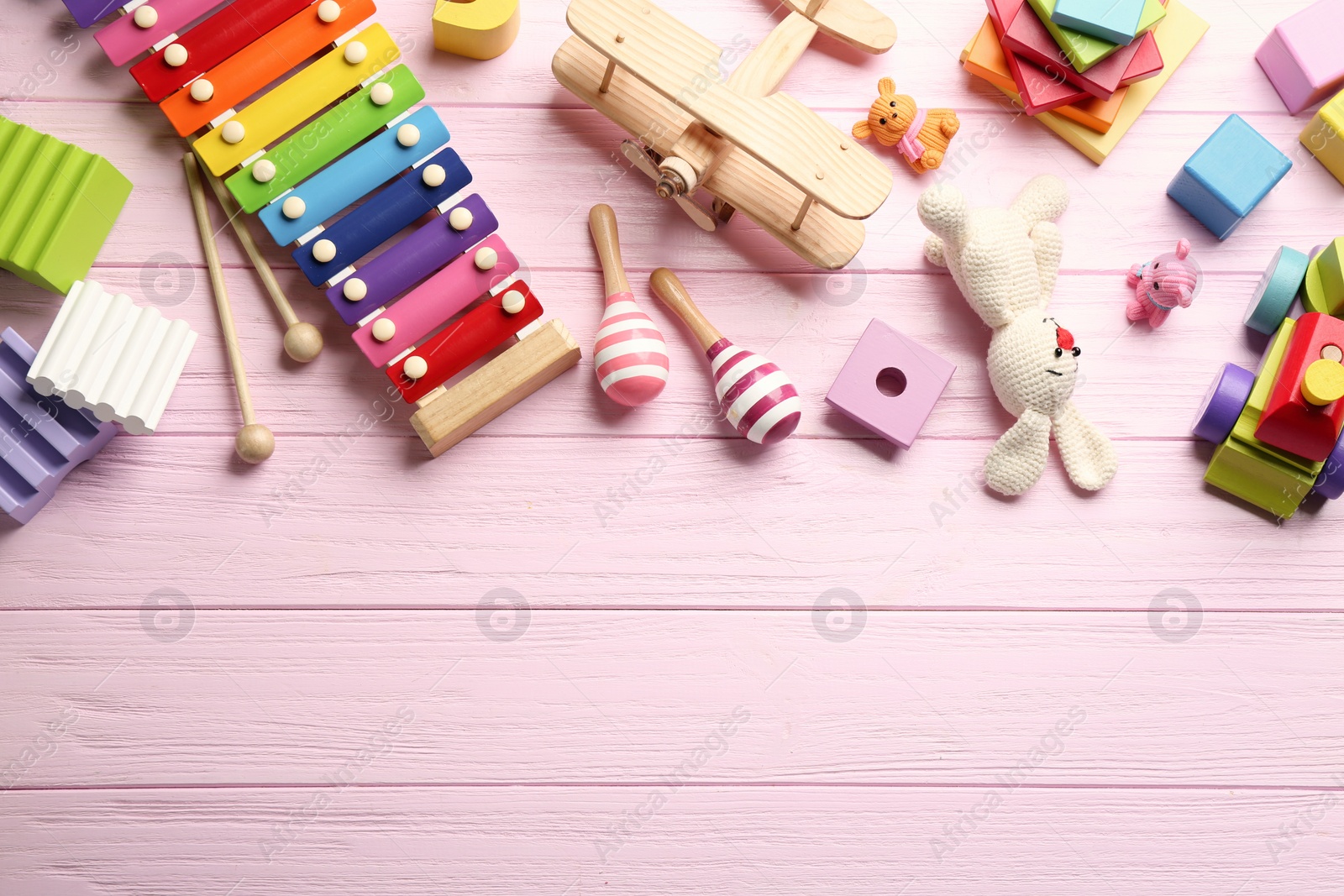 Photo of Different toys on pink wooden background, flat lay. Space for text