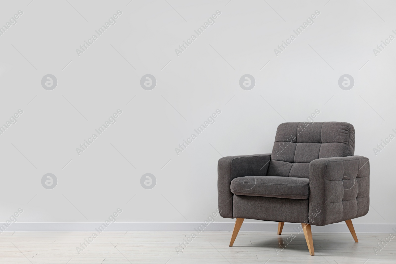 Photo of Comfortable armchair near white wall indoors. Space for text