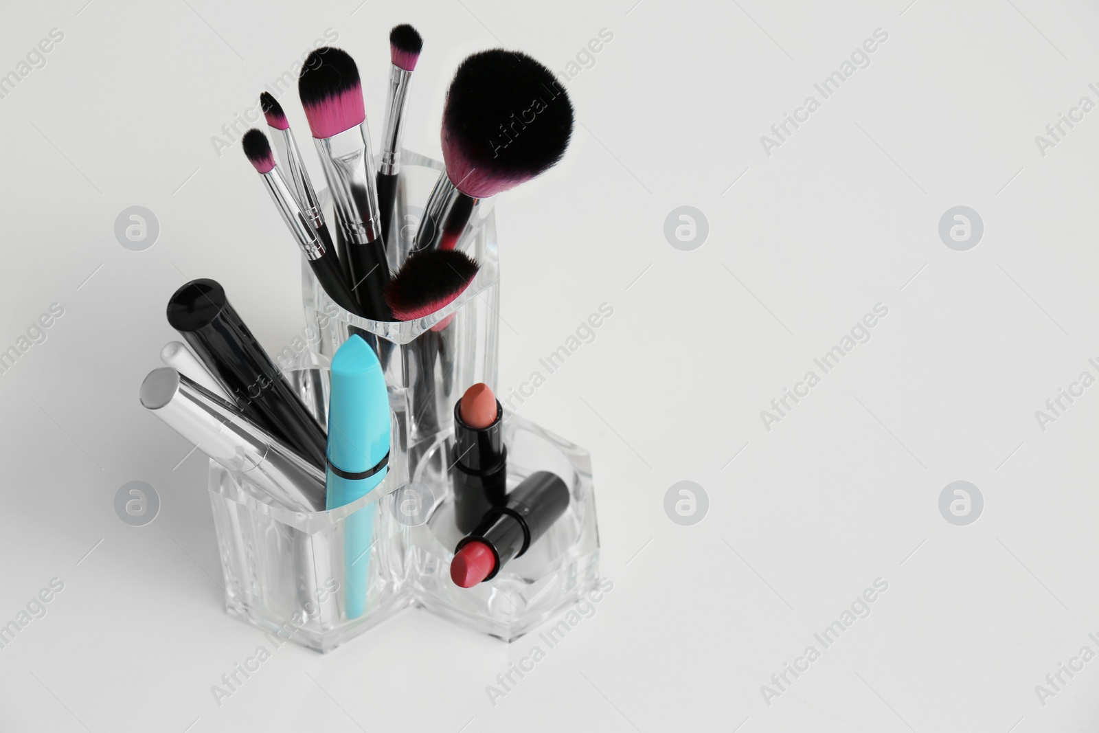 Photo of Organizer with makeup cosmetic products on light table. Space for text