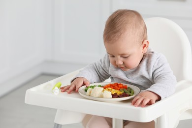 Photo of Cute little baby eating healthy food at home