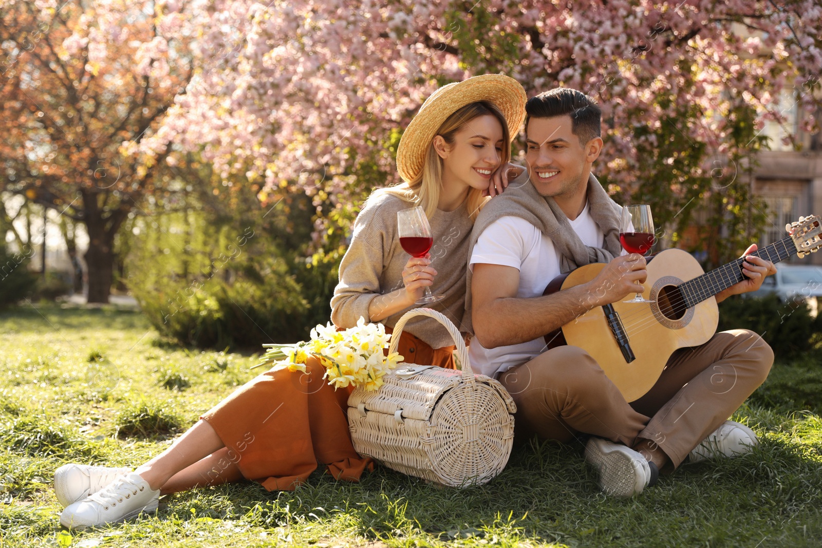 Photo of Lovely couple having picnic in park on sunny spring day