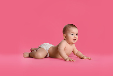 Photo of Cute little baby in diaper on pink background. Space for text