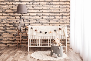 Photo of Stylish baby room interior with comfortable crib