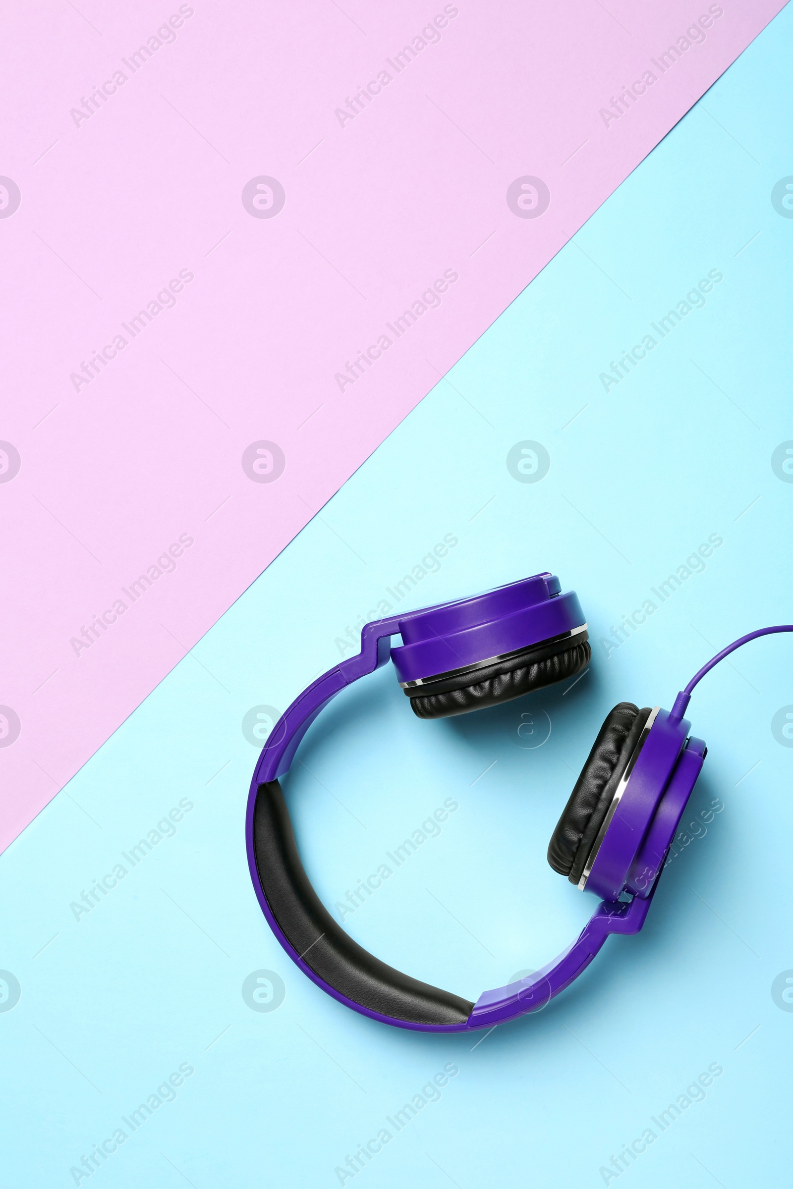 Photo of Stylish headphones on color background, top view. Space for text