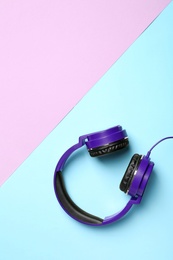 Stylish headphones on color background, top view. Space for text