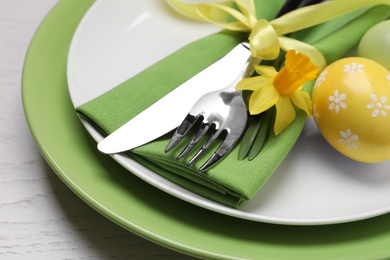 Festive Easter table setting with eggs on white background, closeup