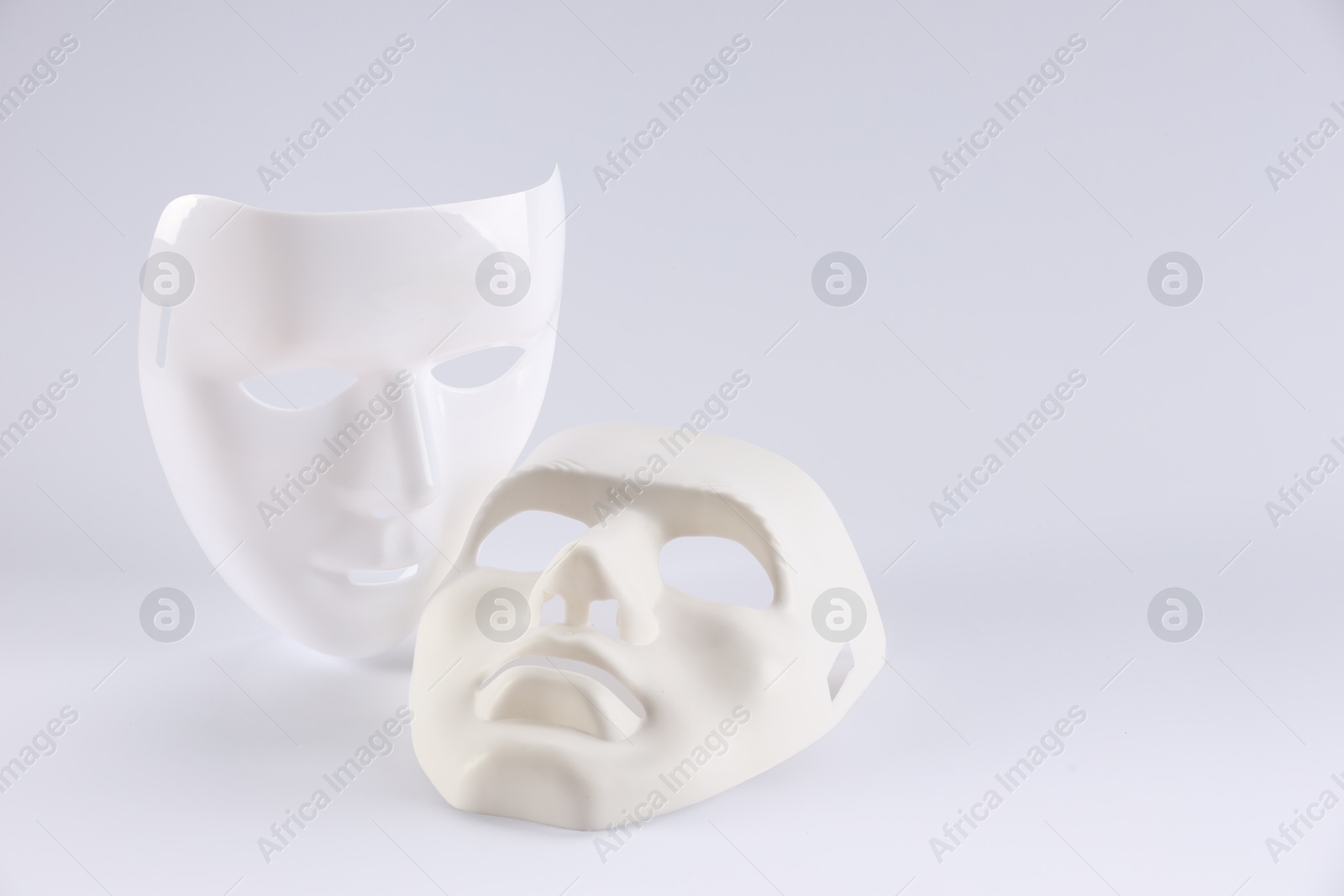 Photo of Plastic face masks on white background, space for text. Theatrical performance