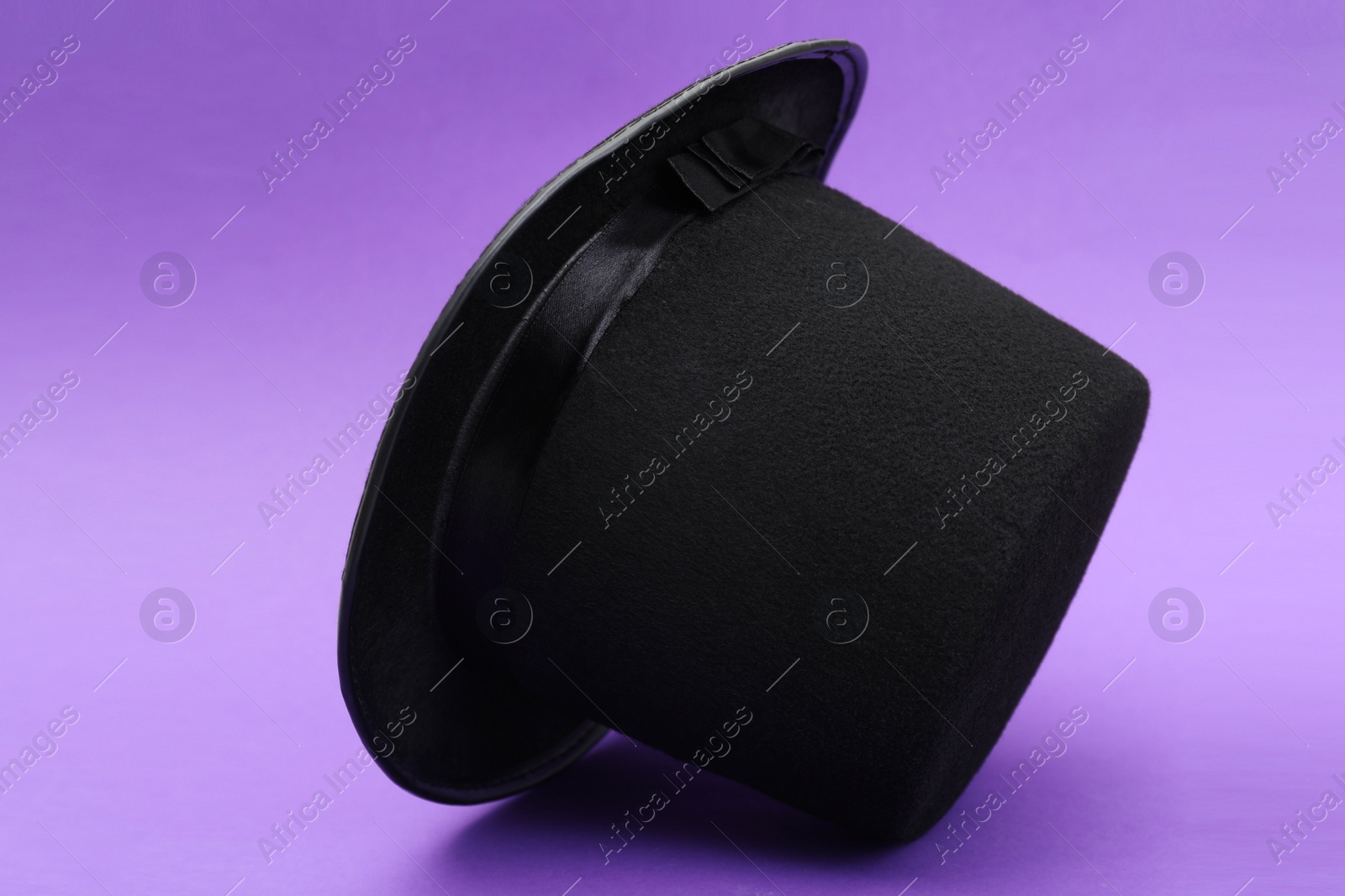 Photo of One magician top hat on violet background