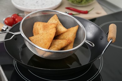 Photo of Heating up samosas on electric stove, closeup