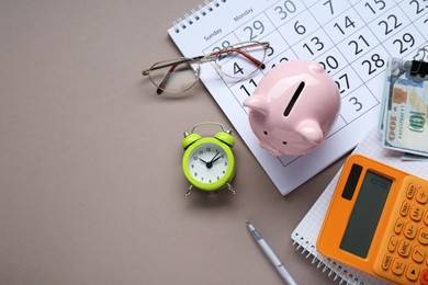 Photo of Flat lay composition with piggy bank, glasses and banknotes on grey background. Space for text