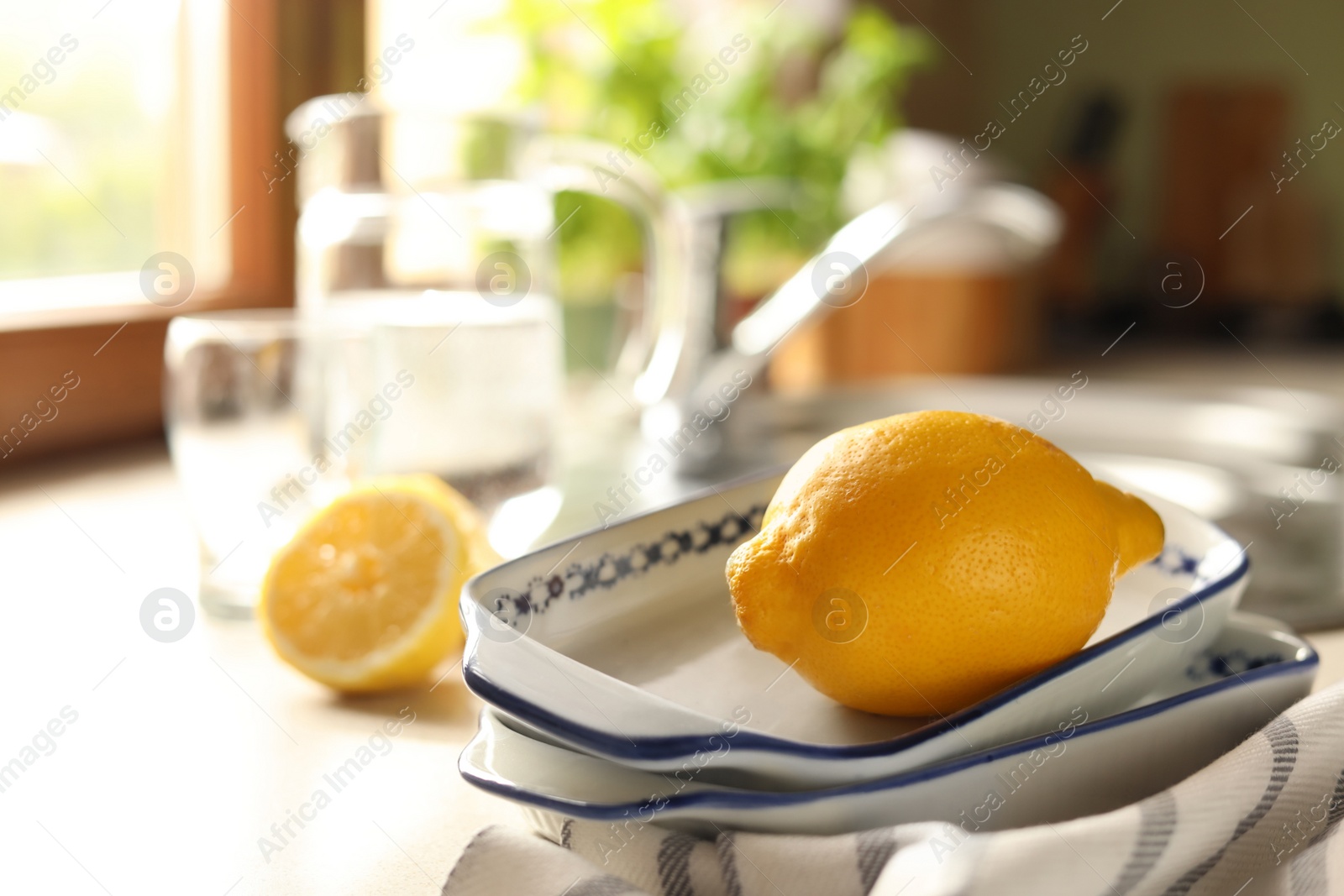 Photo of Fresh ripe lemon on countertop in kitchen, closeup. Space for text