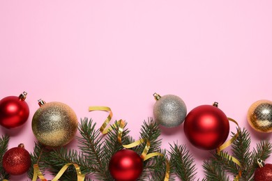 Photo of Shiny Christmas balls, streamers and fir tree branches on pink background, flat lay. Space for text