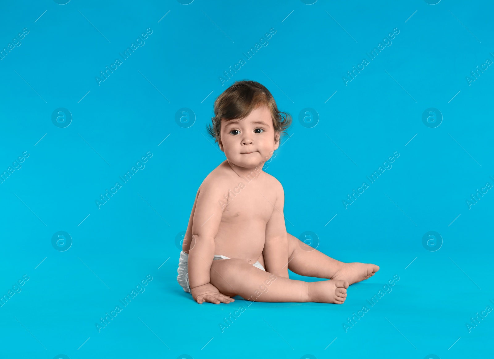 Photo of Cute little baby in diaper on light blue background. Space for text