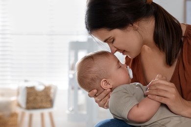 Photo of Happy young mother with her sleeping baby at home. Space for text