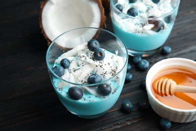 Photo of Composition with glass cup of spirulina smoothie on wooden table