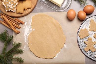 Photo of Making Christmas cookies. Flat lay composition with ingredients and raw dough on grey table