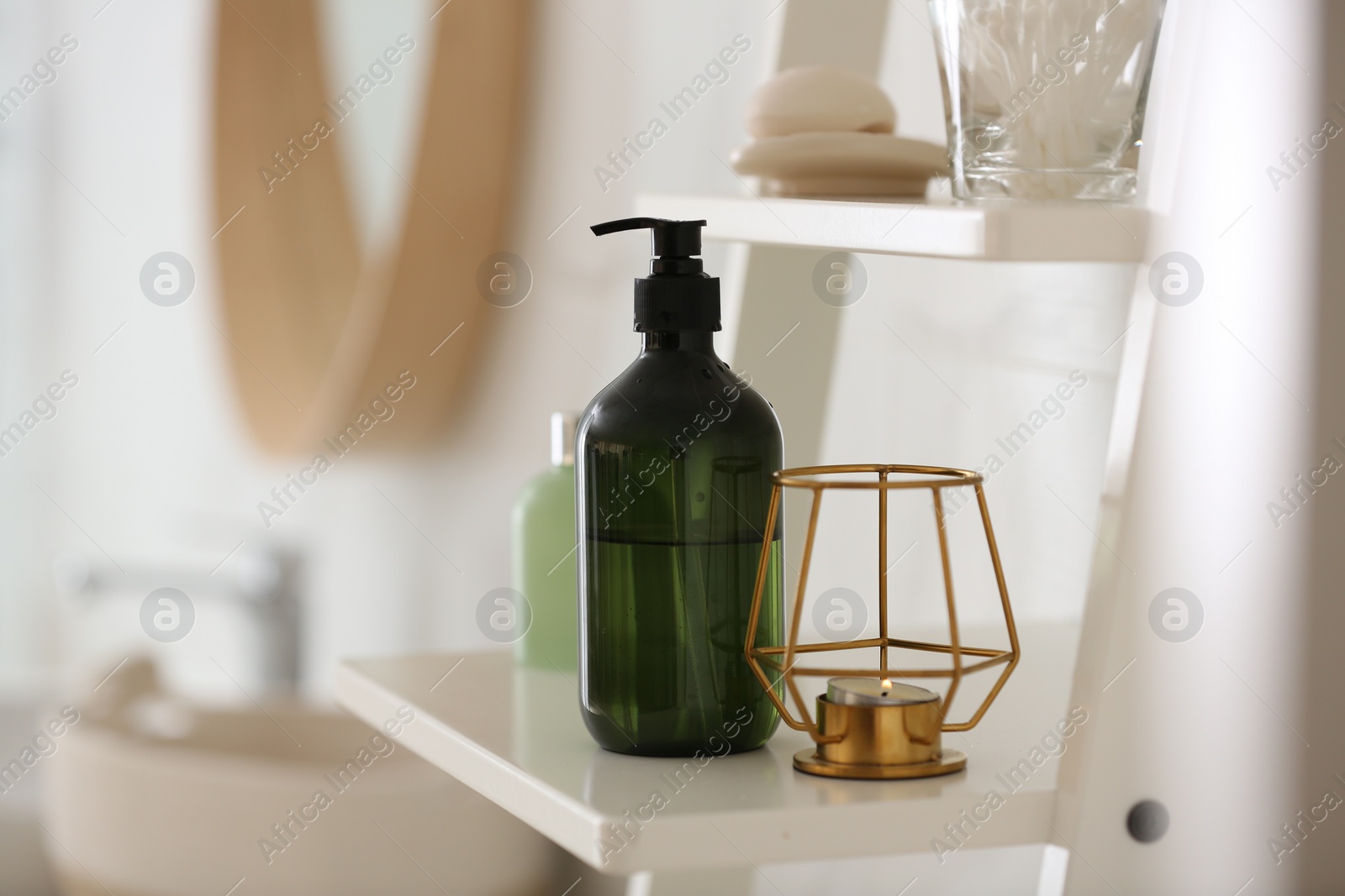 Photo of Green soap dispenser on white shelving unit in bathroom. Space for text