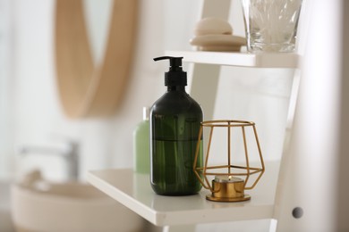 Green soap dispenser on white shelving unit in bathroom. Space for text