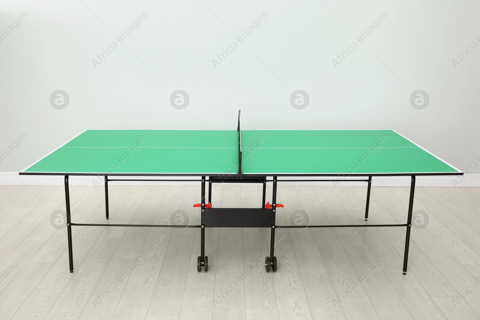 Photo of One green ping pong table with net indoors